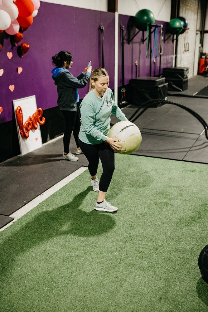 A member training with a medicine ball during class