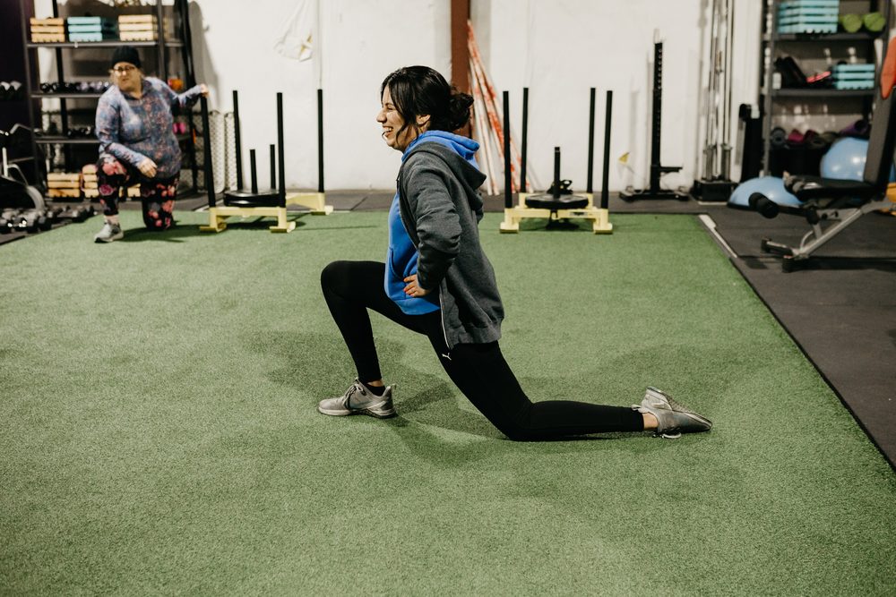 A member laughing through a lunge during class